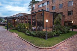 ボゴタにあるHotel Habitel Selectのガラス窓と中庭のある大きな建物