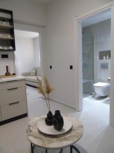 - un salon avec une table et un vase dans l'établissement Nostos Studios Golden Beach, à Chrysi Ammoudia