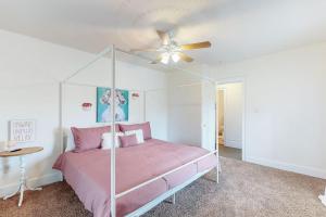 a bedroom with a pink bed and a ceiling fan at The Farmhouse at 1885-Where Past Meets Present in Navarre
