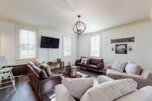 a living room with couches and a chandelier at The Farmhouse at 1885-Where Past Meets Present in Navarre