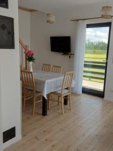 a dining room with a table and chairs and a television at Nowa Śluza Szóstka in Lipusz
