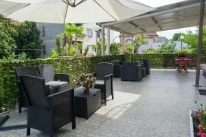 a patio with chairs and tables and an umbrella at Hotel alla giustizia in Mestre