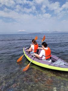 three people in a kayak in the water at Vikos Beach Apartments in Paralía Iríon
