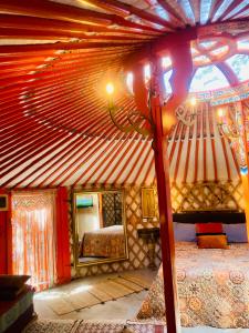 1 dormitorio con cama y espejo en una habitación en Yurta Arco Iris en Riba-Roja De Turia