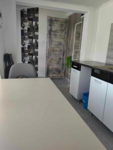 cocina con encimera blanca y escritorio en Sweety-Apartman en Mátészalka