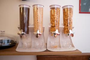 a group of four glass containers filled with food at Hotel alla giustizia in Mestre