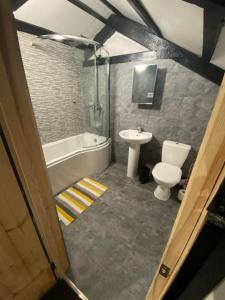 a bathroom with a tub and a toilet and a sink at Bumblebee Cottage in Redruth +12 photos