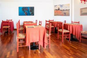 a room with tables and chairs with red table cloth at Hotel alla giustizia in Mestre