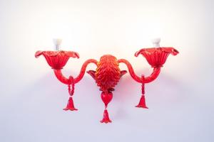 three red glass candle holders on a white background at Hotel alla giustizia in Mestre