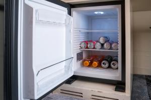 an open refrigerator filled with lots of soda cans at Hotel alla giustizia in Mestre