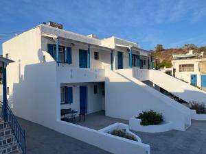 - un bâtiment blanc avec des portes et des escaliers bleus dans l'établissement ANCHOR, à Provatas