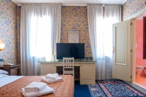 a bedroom with a bed and a desk with a television at Hotel alla giustizia in Mestre
