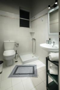 CHIOS HOTEL في Katarráktis: حمام ابيض مع مرحاض ومغسلة