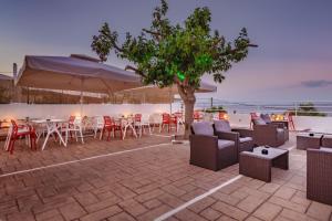 a patio with chairs and tables and an umbrella at CHIOS HOTEL in Katarráktis