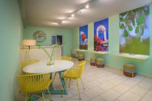 une salle à manger avec une table et des chaises jaunes dans l'établissement CHIOS HOTEL, à Katarráktis