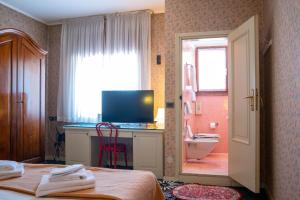 a bedroom with a bed and a desk with a television at Hotel alla giustizia in Mestre
