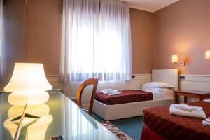 a hotel room with two beds and a window at Hotel alla giustizia in Mestre