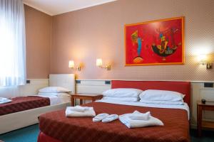 a hotel room with two beds with towels on them at Hotel alla giustizia in Mestre
