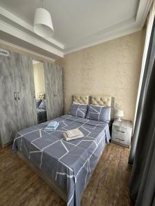 a bedroom with a large bed with a blue comforter at Rustaveli Apartment 113 in Kutaisi