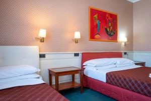 a hotel room with two beds and a painting on the wall at Hotel alla giustizia in Mestre
