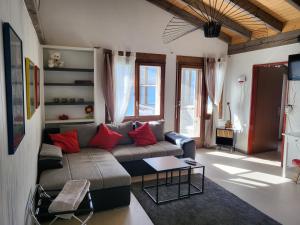 Hotel Platten Apartment في غيراسو: غرفة معيشة مع أريكة ووسائد حمراء