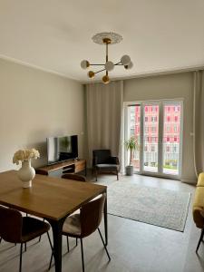 een woonkamer met een tafel, stoelen en een televisie bij Maison Floran appartamento in centro a Trieste in Trieste