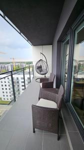 balcone con 2 sedie e altalena di Apartament Bułgarska 59 - sypialnia i salon - 40m2 - self check in 24h a Poznań