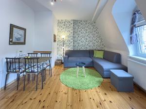a living room with a blue couch and a table at Apartment NELY 2 - spa city centre in Karlovy Vary