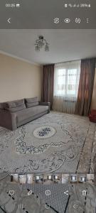 uma sala de estar com um sofá e um tapete grande em 2-комнатная квартира в административном центре. em Türkistan
