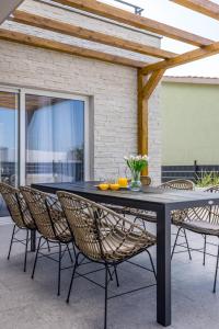 ein schwarzer Tisch mit Stühlen und Orangen darauf in der Unterkunft Villa Teuta in Kaštel Stari