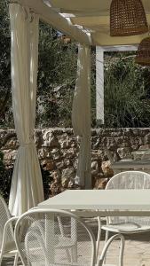 a white table and chairs under an umbrella at Przno Apartment Most Oliva in Vrijesno