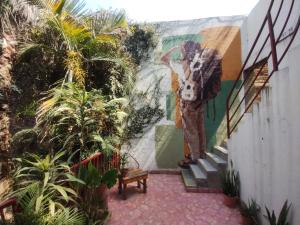 a mural of a man standing on a wall next to stairs at Hostel Hospedarte Chapultepec in Guadalajara +130 photos