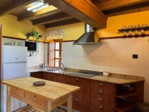 a kitchen with a white refrigerator and a wooden table at Casa Rural El Salvijo in Monte