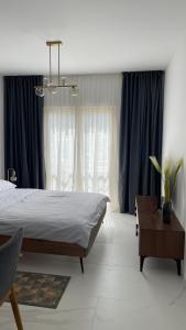 a bedroom with a large bed and blue curtains at Przno Apartment Most Oliva in Vrijesno