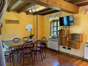 uma sala de jantar com mesa e cadeiras e uma televisão em Casa Rural El Salvijo em Monte