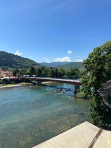 a bridge over a river with mountains in the background at BEHAR Hotel in Goražde