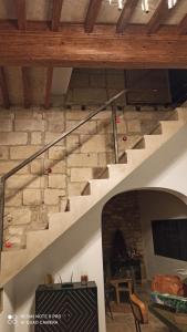 una escalera en una sala de estar con una pared de piedra en La Barrack Broc en Aimargues