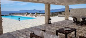 a patio with a pool and chairs and a table at Villa celine in Aliki