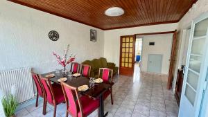 a dining room with a table and red chairs at Appartement familial à Paris in Villejuif