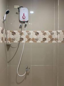 een douche met een douchekop in de badkamer bij Llaguno City Inn in General Santos