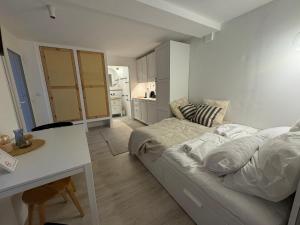 a white room with a bed and a desk in it at Bánhiday H31 Beach house in Balatonakarattya