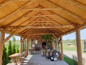 einem großen Holzpavillon mit Bänken und Tischen in der Unterkunft Casa Fericirii in Cîrţişoara