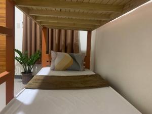 a bedroom with a bed with a wooden canopy at Llaguno City Inn in General Santos