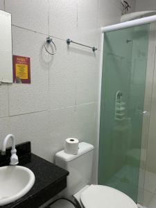 y baño con ducha, aseo y lavamanos. en Pousada Las Palmas, en Guarujá
