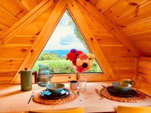 a table with a vase of flowers on a table in a cabin at Stairway to Devon in High Bickington