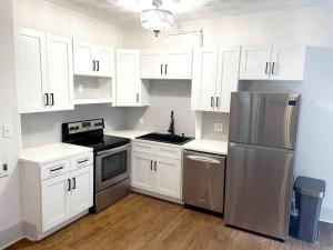 a kitchen with white cabinets and a stainless steel refrigerator at Downtown Knoxville Gem with King Bed and Free Parking in Knoxville