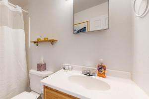 a white bathroom with a sink and a mirror at Serenity Cove Cottage in Camden +25 photos