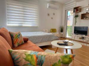 un soggiorno con divano, letto e tavolo di Afrika Apartment a Brčko