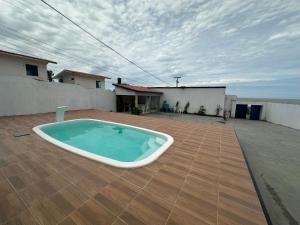 a large swimming pool on a patio with a house at Casa de praia in São-José-do-Ribamar