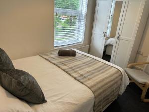 uma cama num quarto com uma janela em Modern Manchester house, near city centre & free parking em Manchester